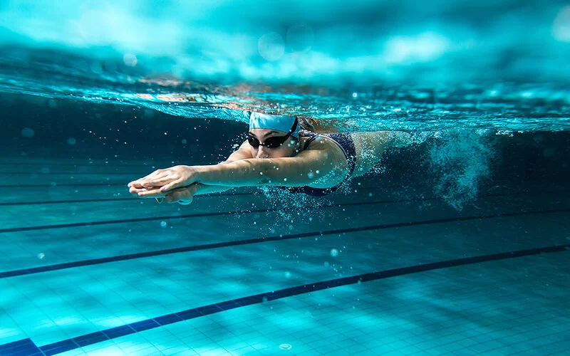 Eine Frau taucht beim Schwimmen unter Wasser.